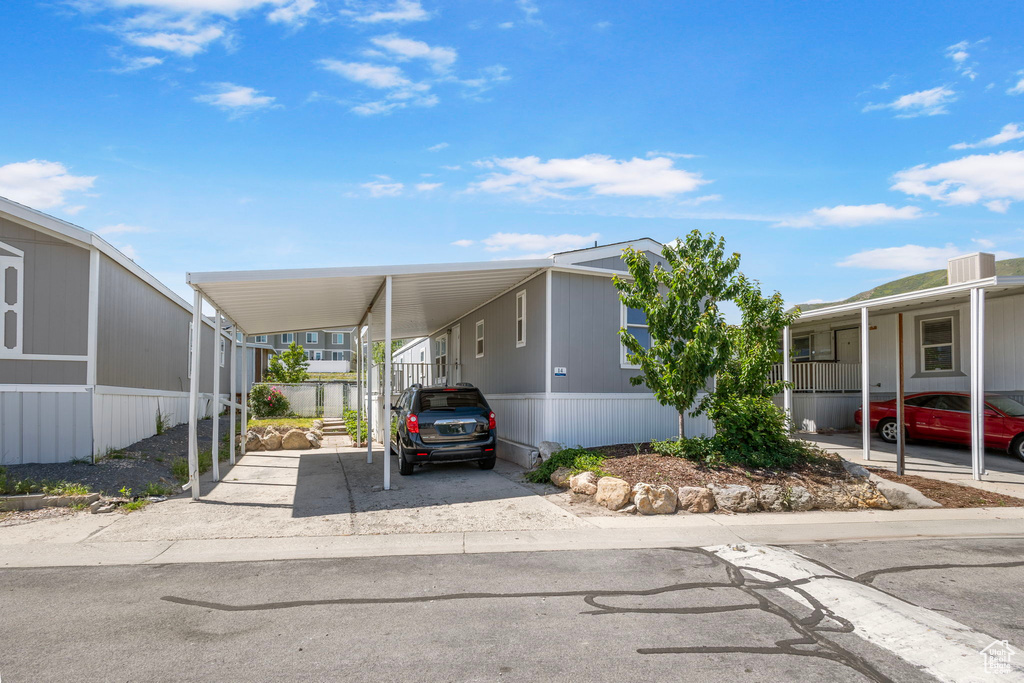 Manufactured / mobile home featuring an attached carport and driveway