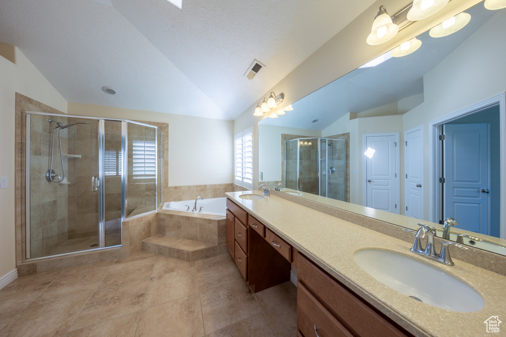 Full bathroom with vaulted ceiling, double vanity, a bath, a stall shower, and tile patterned flooring
