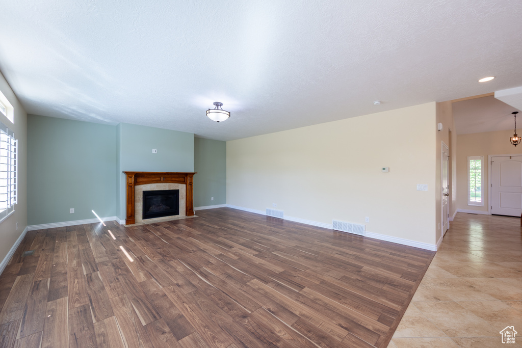 Unfurnished living room with wood finished floors, a fireplace, and baseboards