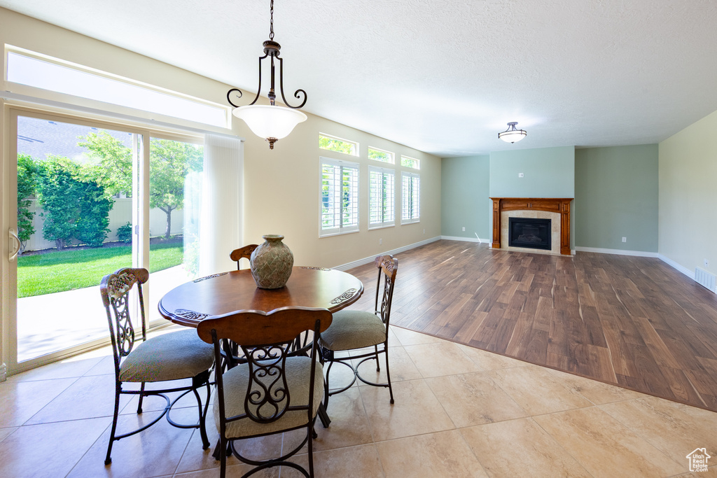 Tiled dining area with a tiled fireplace and baseboards