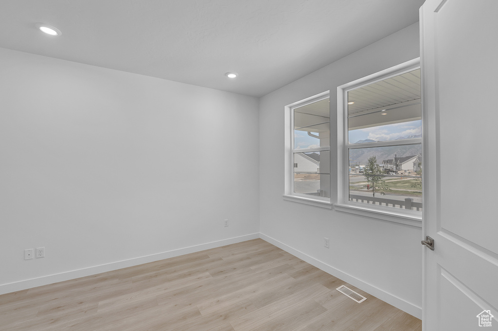 Unfurnished room featuring light wood finished floors, baseboards, and recessed lighting