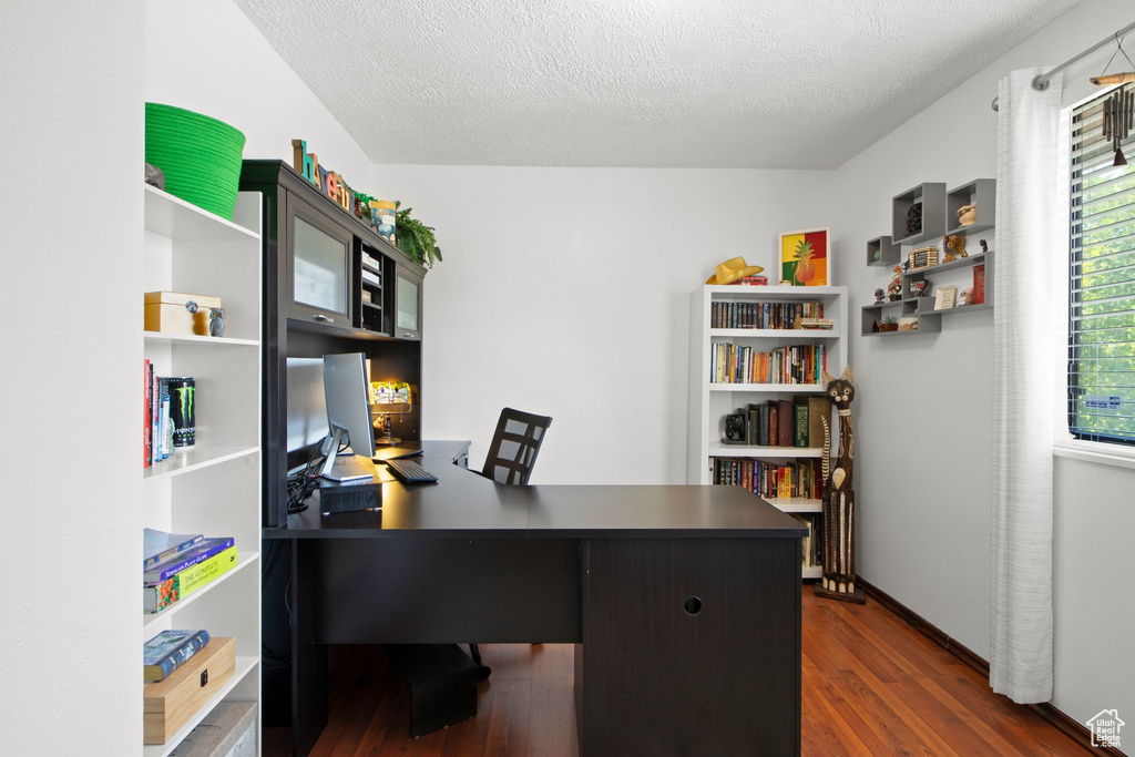 Office with dark wood-type flooring and a textured ceiling