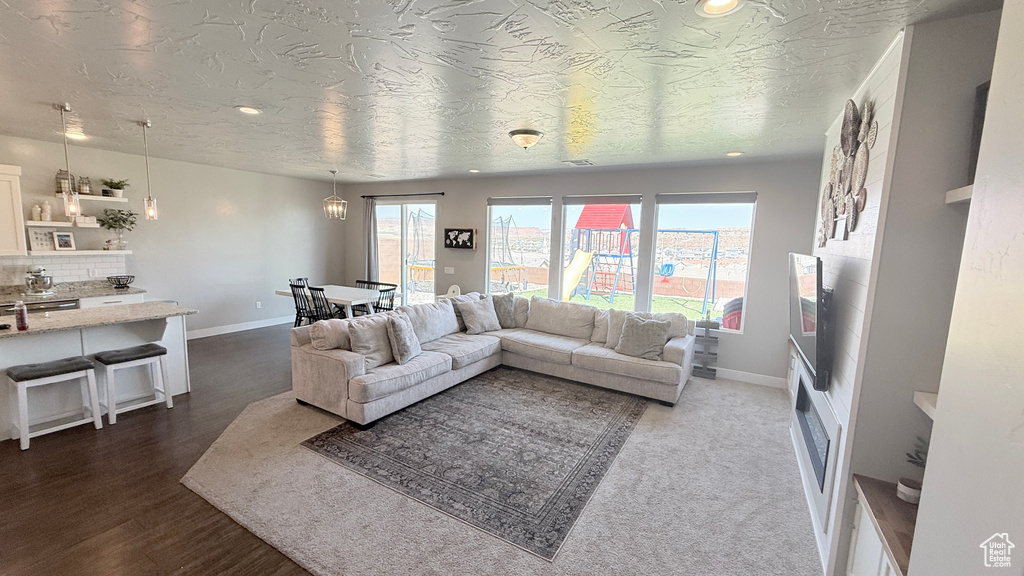 Living area with baseboards, recessed lighting, and dark wood finished floors