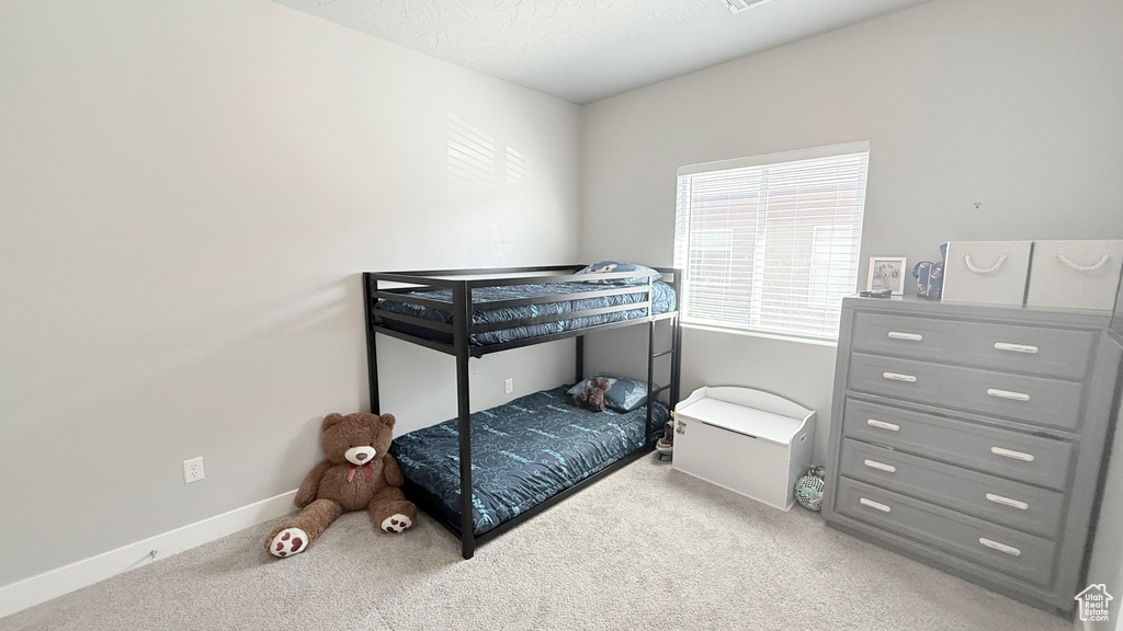 Bedroom featuring carpet floors and baseboards