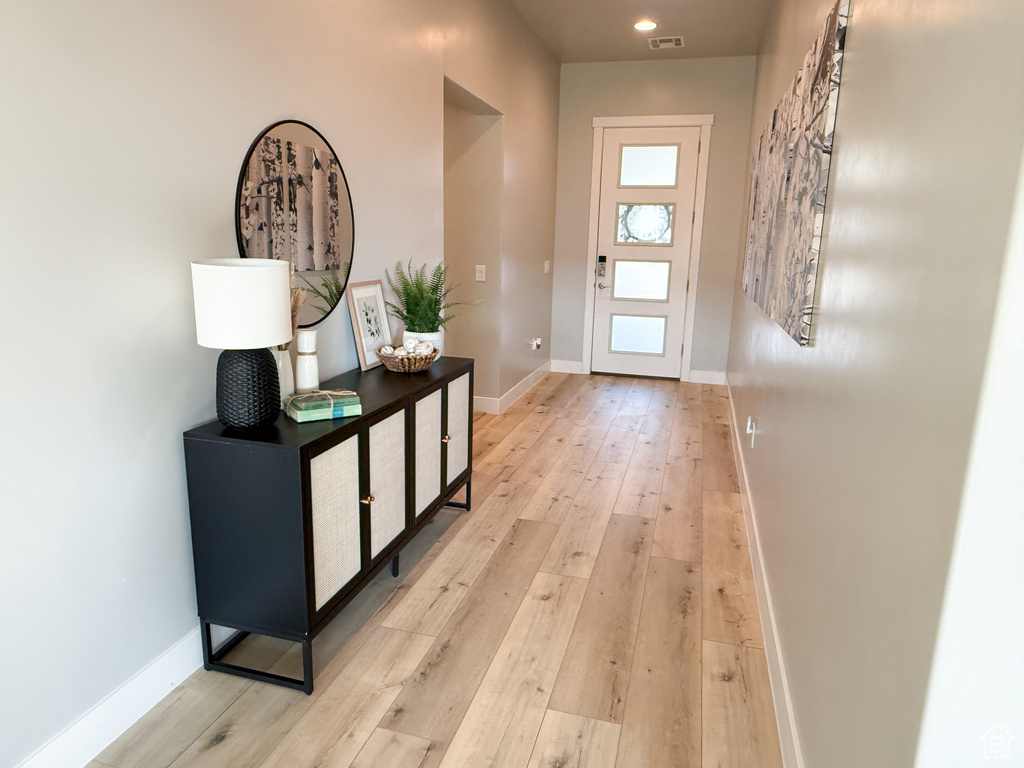 Entryway with light wood-style floors and recessed lighting