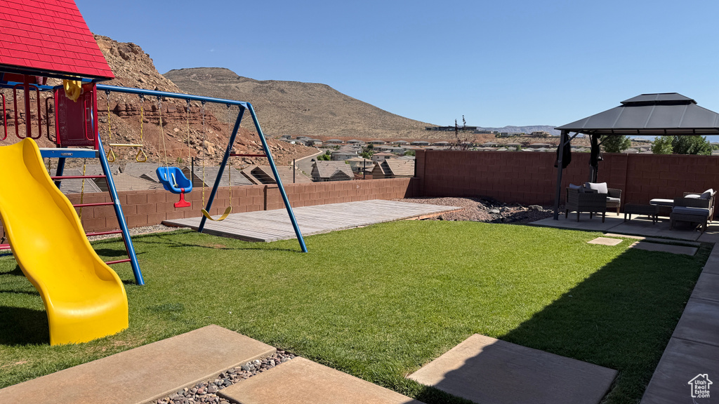 View of yard with a playground, a mountain view, an outdoor hangout area, and a gazebo