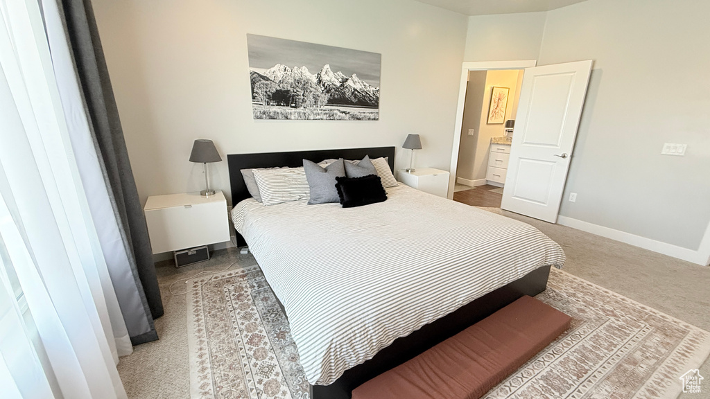 Bedroom with baseboards and light colored carpet