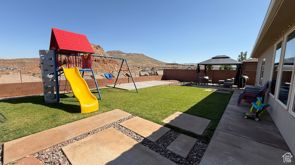 View of yard with a gazebo, a mountain view, a patio area, and a playground