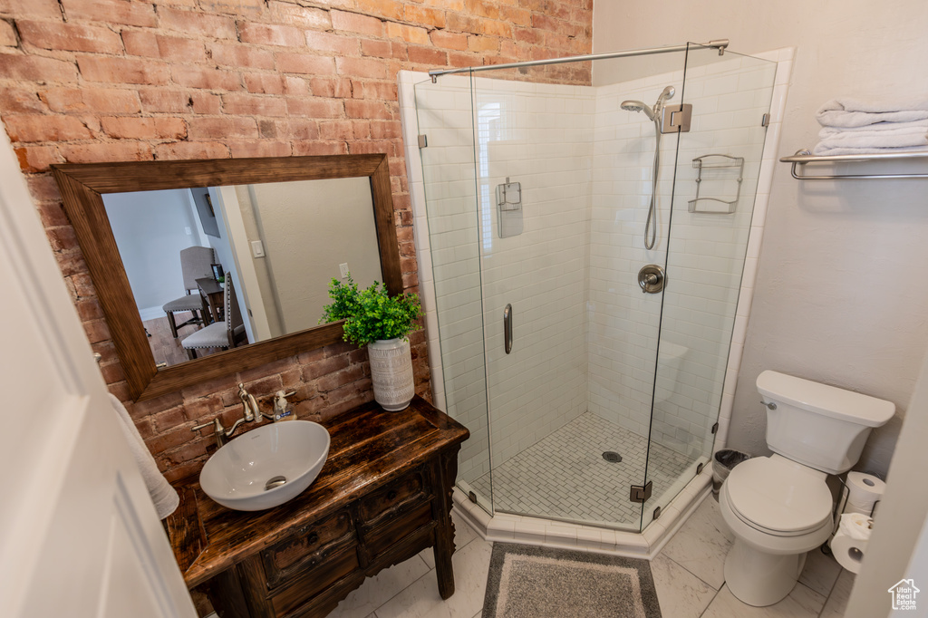 Bathroom featuring toilet, a shower stall, and vanity