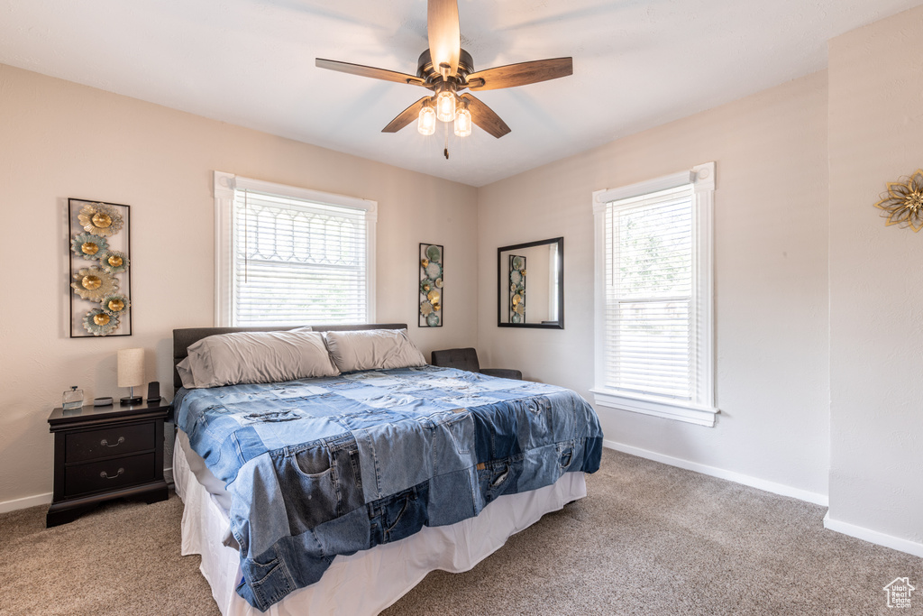 Carpeted bedroom featuring baseboards and ceiling fan
