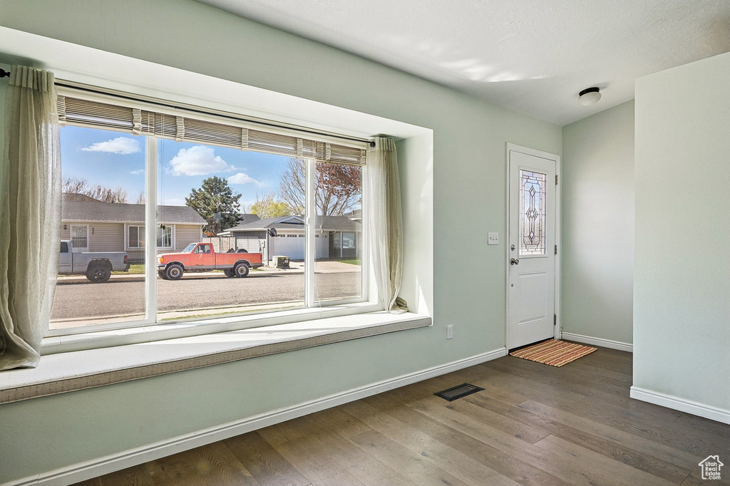 Entryway with baseboards and wood finished floors