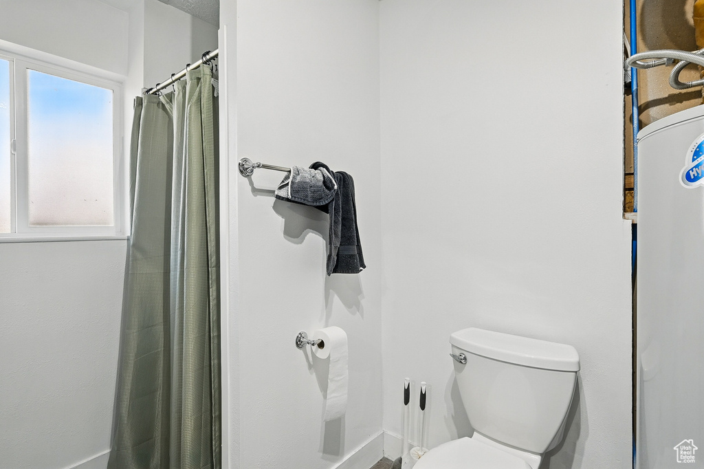 Full bathroom featuring toilet and a shower with shower curtain