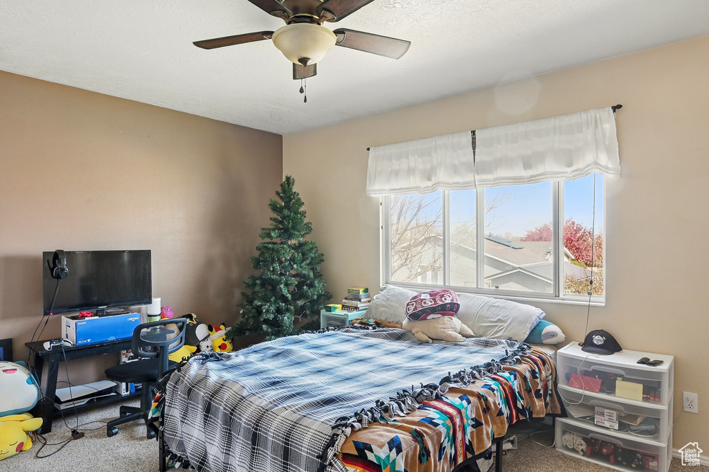 Carpeted bedroom featuring a ceiling fan