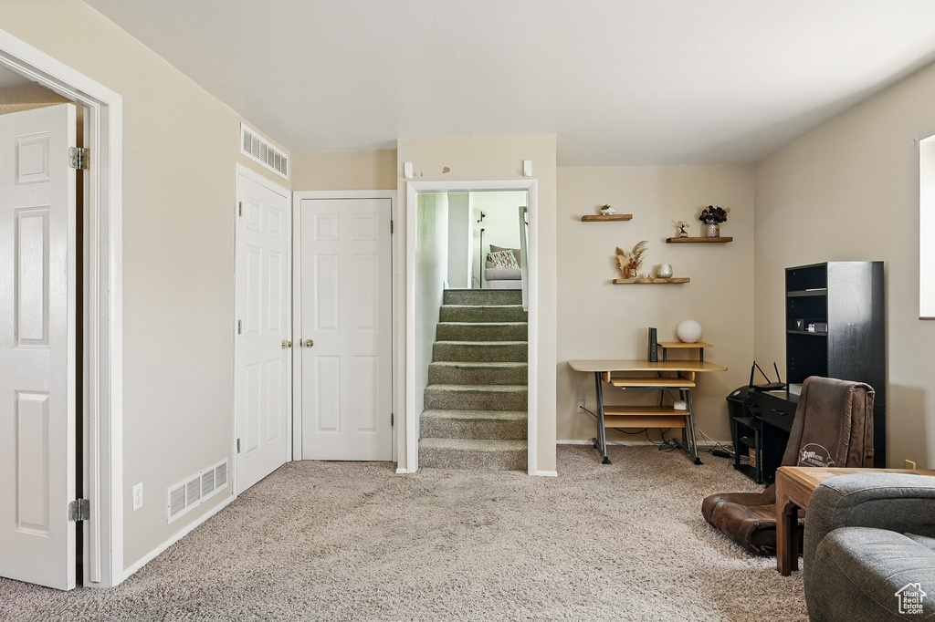 Sitting room with carpet flooring and stairs
