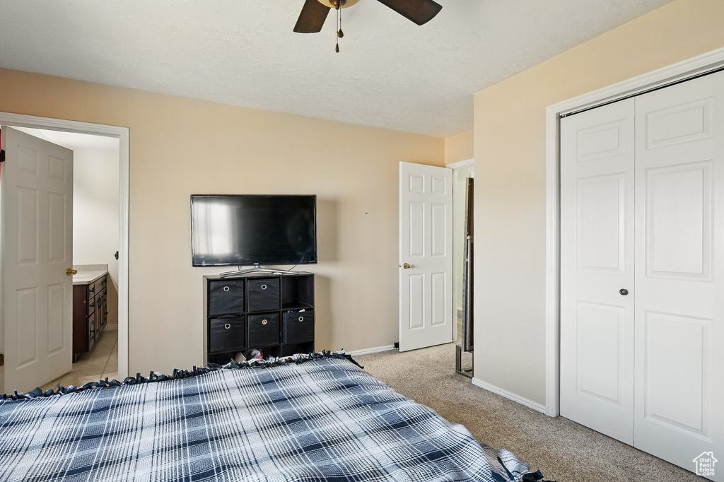 Bedroom featuring light carpet, baseboards, a closet, and ceiling fan