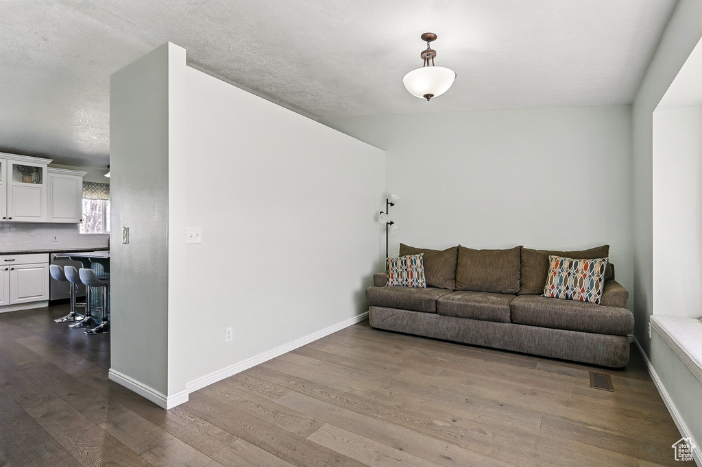 Living area featuring dark wood-style flooring and baseboards
