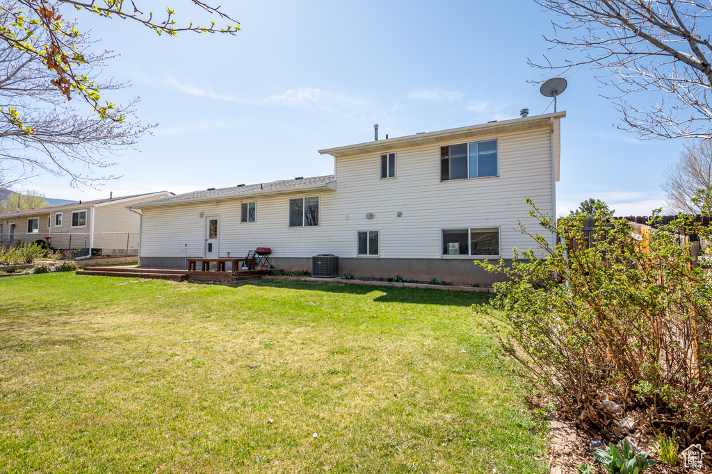 Back of property featuring central AC unit and a deck