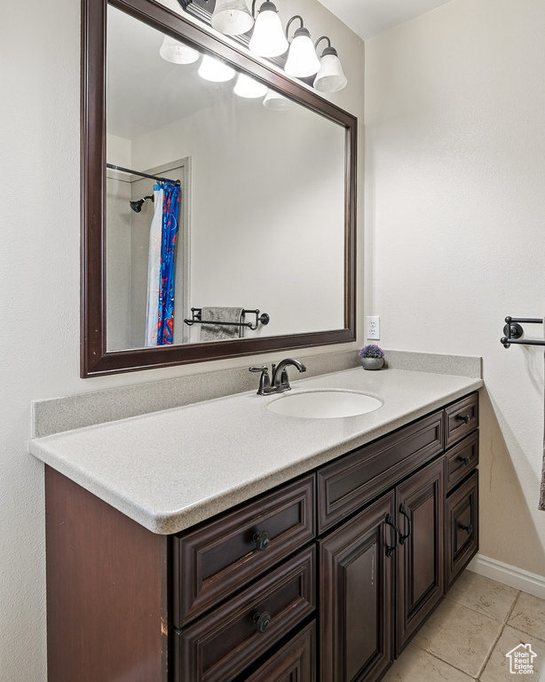Bathroom with vanity, baseboards, tile patterned floors, and a shower with curtain