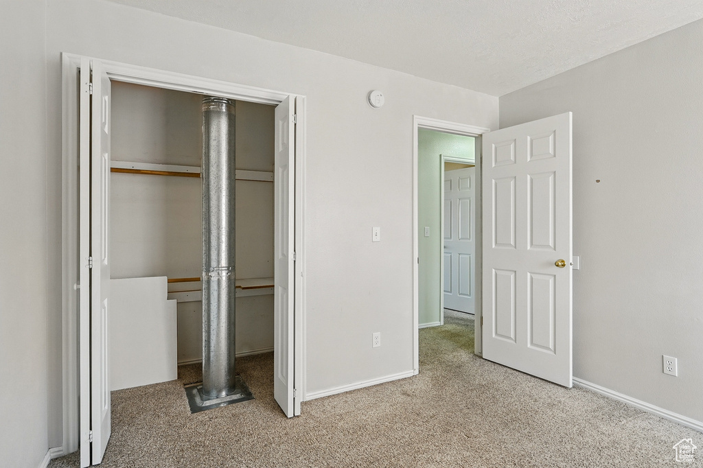 Unfurnished bedroom featuring a closet, carpet flooring, and baseboards