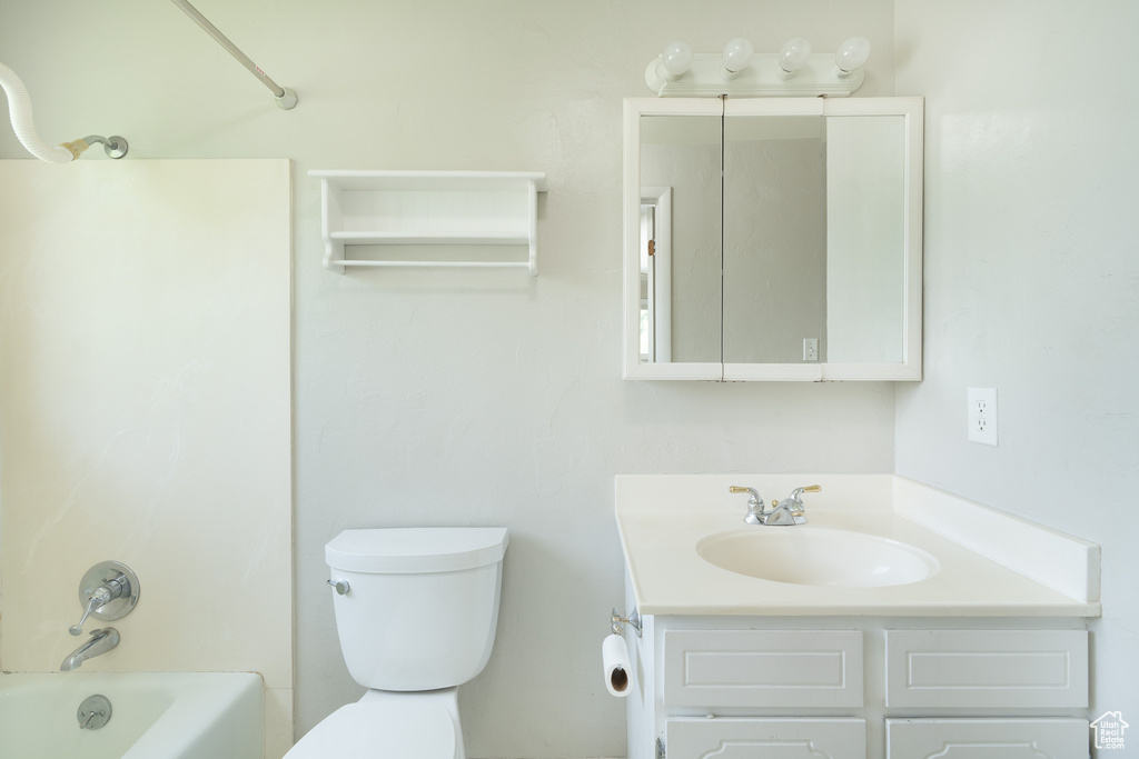 Full bathroom with toilet, vanity, and shower / tub combination