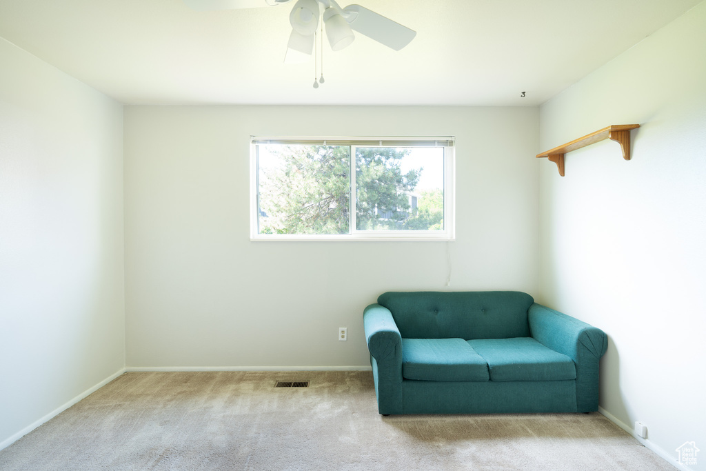 Sitting room featuring ceiling fan, carpet floors, and baseboards