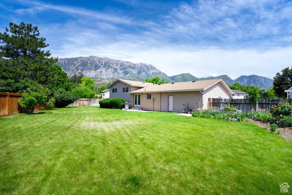 Rear view of property with a mountain view, entry steps, and a patio area