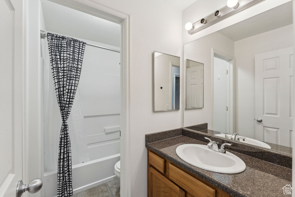 Bathroom with vanity, toilet, shower / tub combo with curtain, and tile patterned flooring