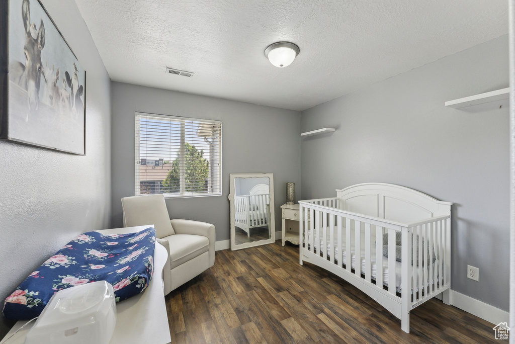 Bedroom featuring wood finished floors, baseboards, and a textured ceiling