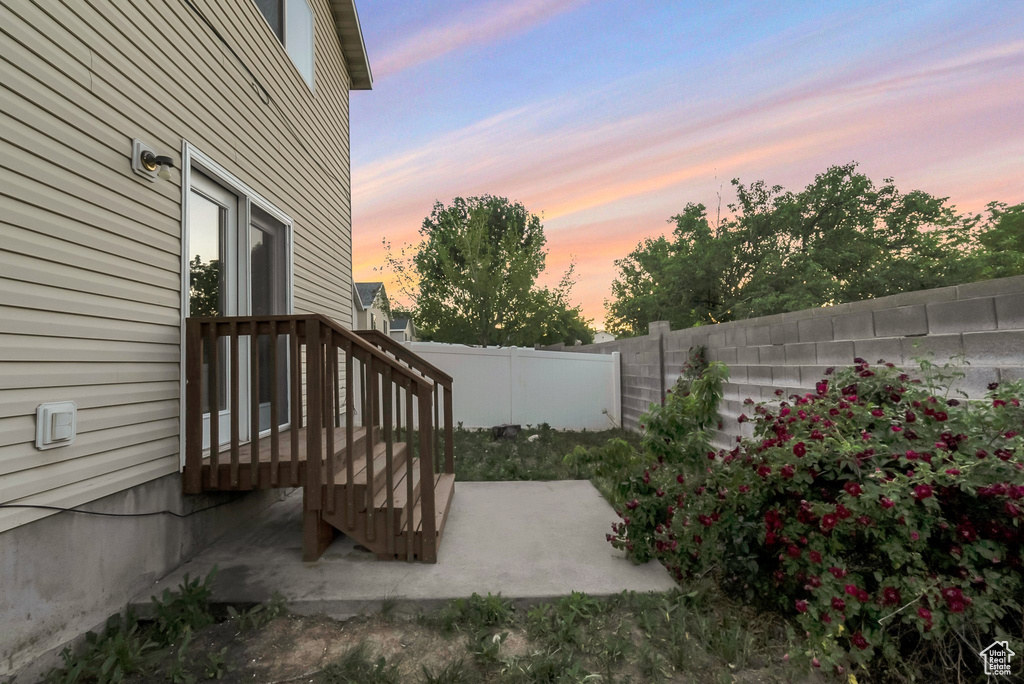 Patio terrace at dusk with a fenced backyard and a patio