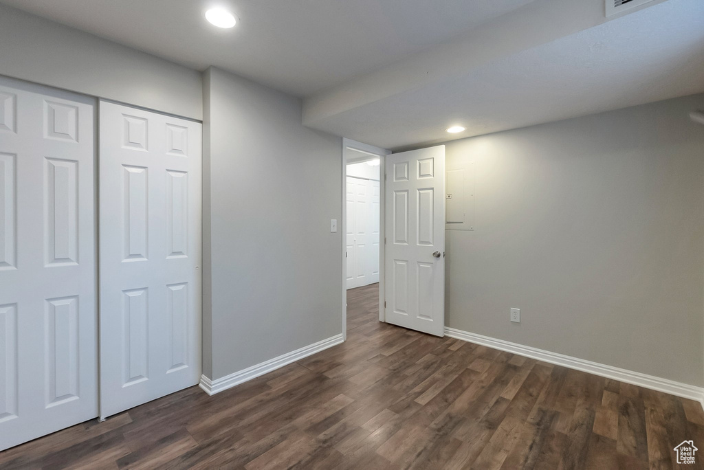 Unfurnished bedroom featuring baseboards, dark wood-type flooring, recessed lighting, and a closet