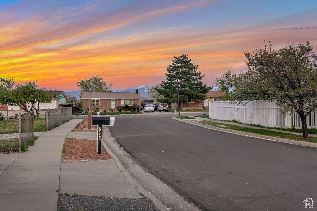 View of asphalt street featuring sidewalks and curbs