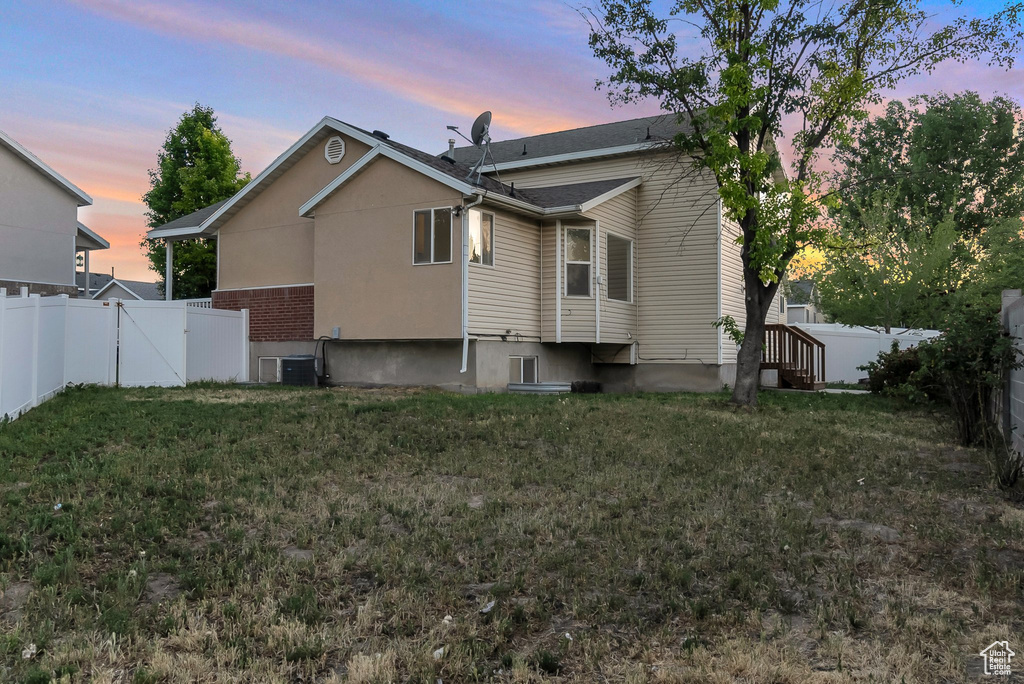 Back of property featuring central AC and a gate