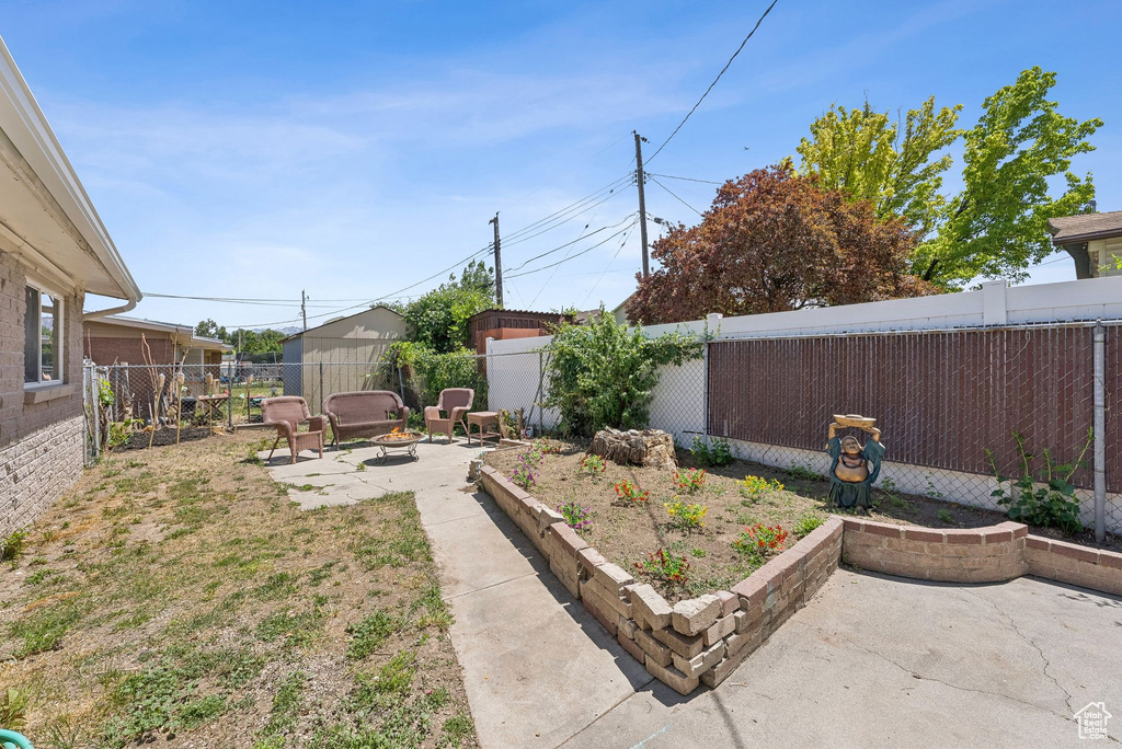 Fenced backyard with a patio and an outdoor fire pit