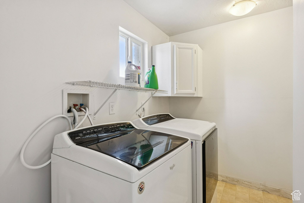Laundry area with washer and dryer, cabinet space, and baseboards