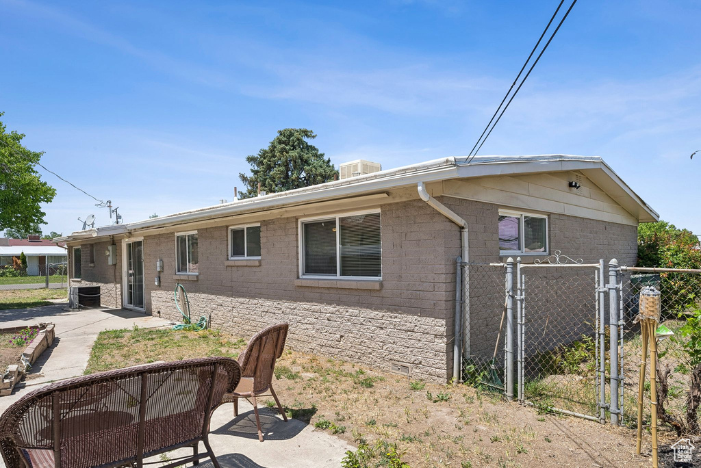 Rear view of property featuring a patio area, a gate, and central air condition unit