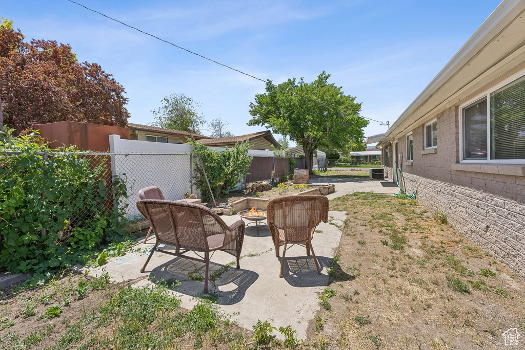 Fenced backyard with a fire pit and a patio area
