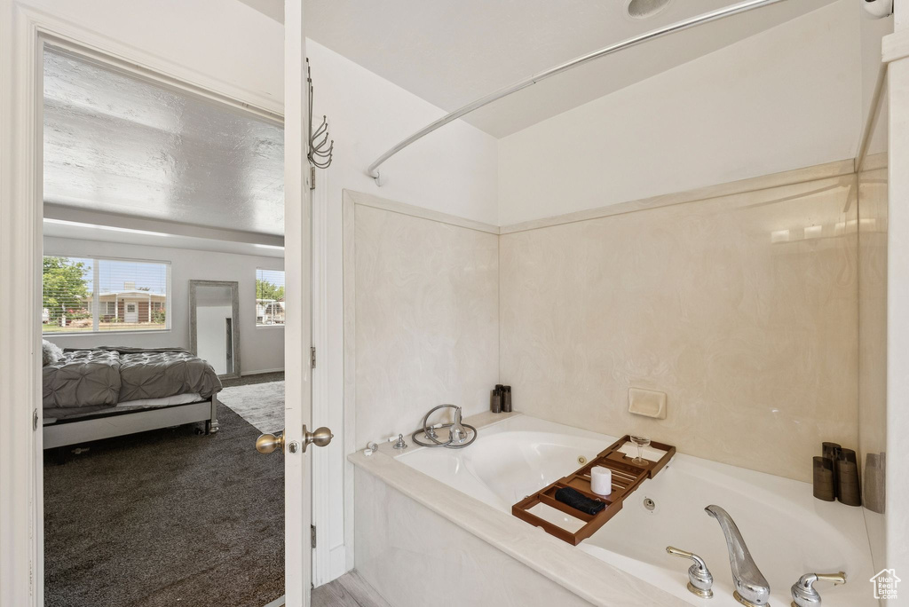 Full bathroom with a tub with jets and connected bathroom