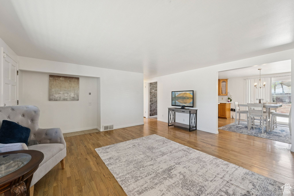 Living area featuring a chandelier, light wood-type flooring, and baseboards