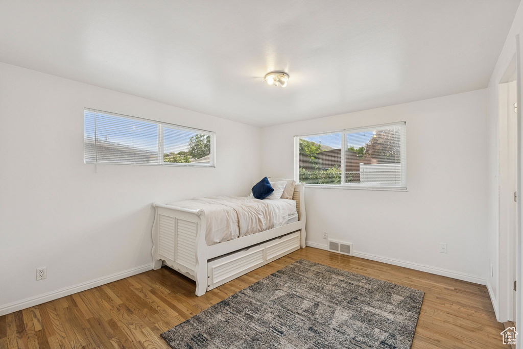 Bedroom with wood finished floors and baseboards