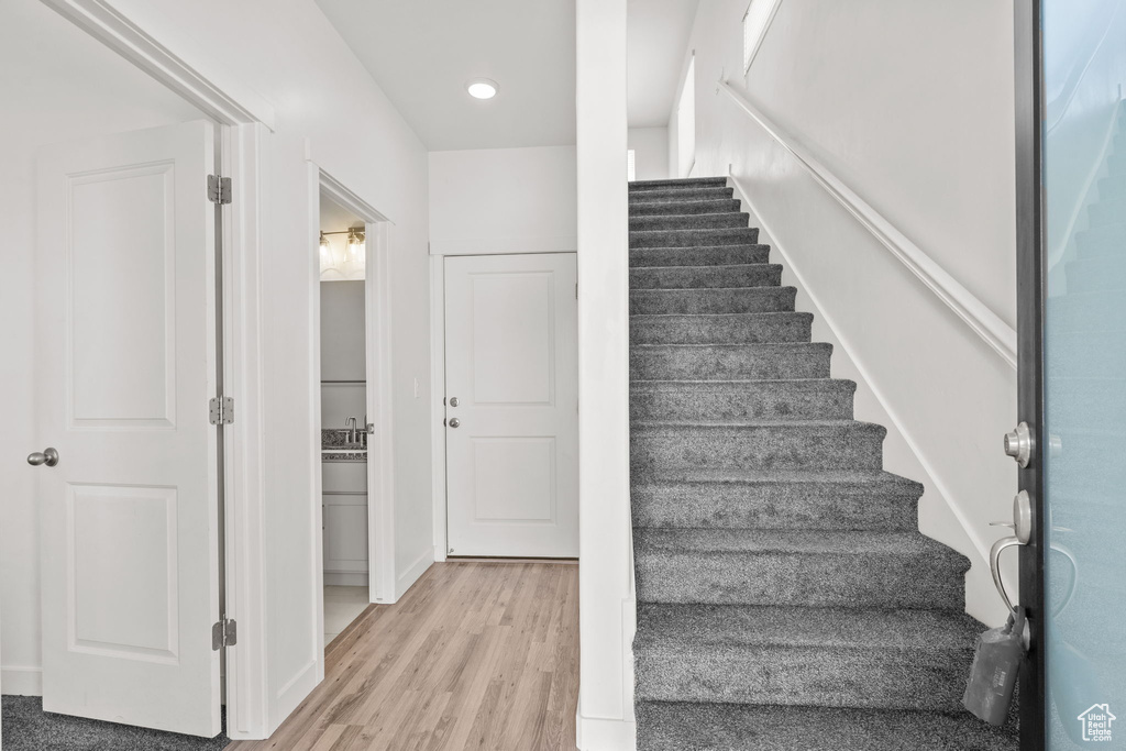 Stairway with wood finished floors and recessed lighting