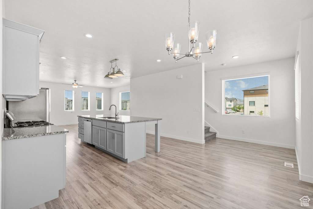 Kitchen with a sink, recessed lighting, stainless steel dishwasher, light wood-style flooring, and open floor plan