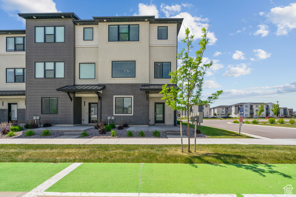 Multi unit property featuring a residential view and a front yard