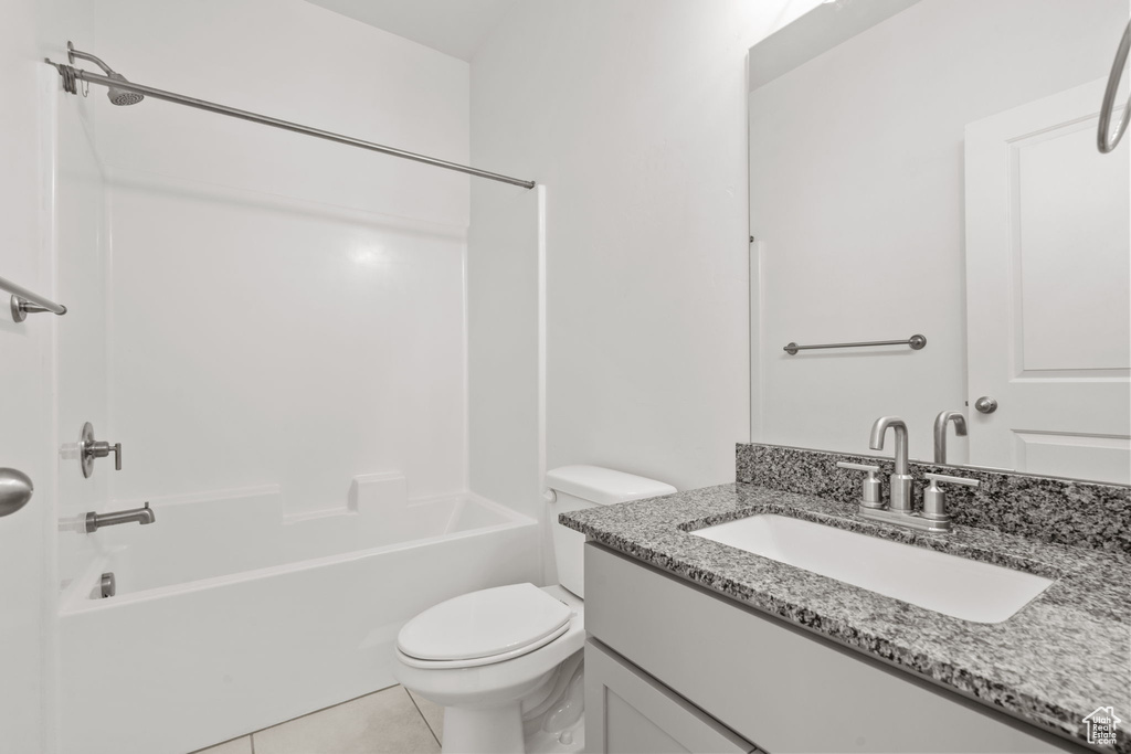 Bathroom with vanity, toilet, bathing tub / shower combination, and tile patterned flooring