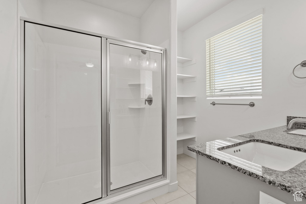 Full bath featuring a stall shower, vanity, and tile patterned flooring