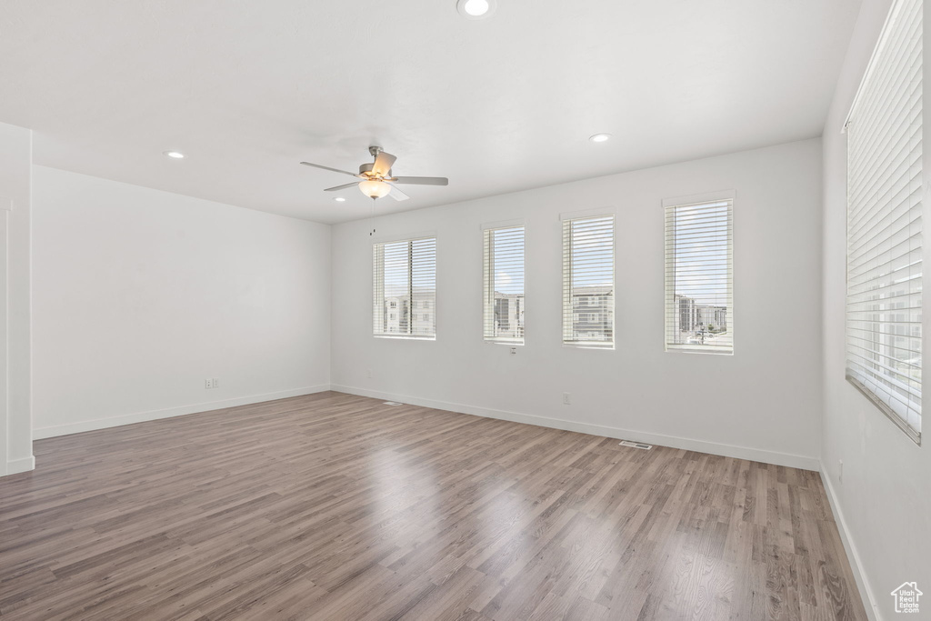 Spare room with a ceiling fan, light wood-style floors, baseboards, and recessed lighting