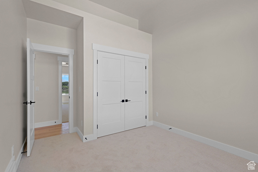Unfurnished bedroom featuring carpet floors, a closet, and baseboards