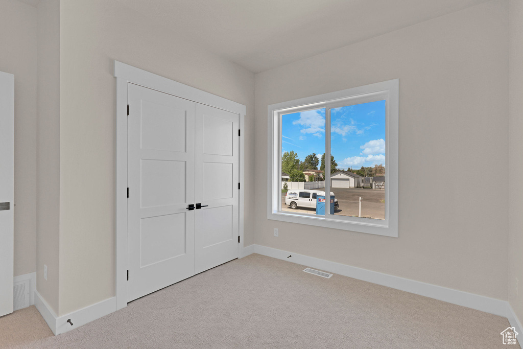 Unfurnished bedroom with carpet floors, baseboards, and a closet