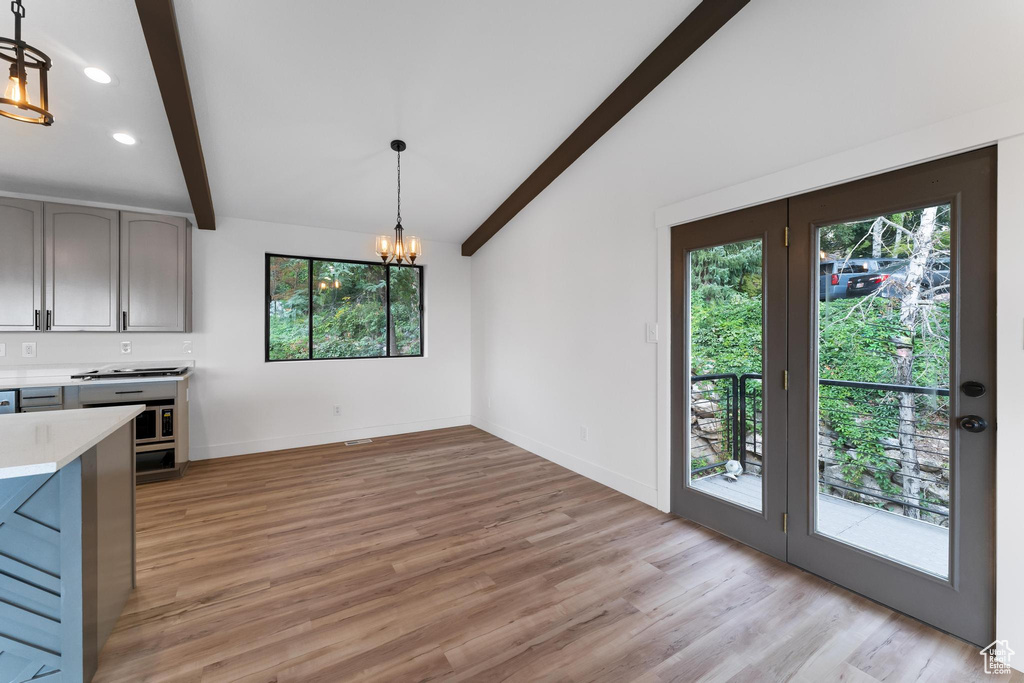 Unfurnished dining area featuring a chandelier, light wood-type flooring, baseboards, and recessed lighting