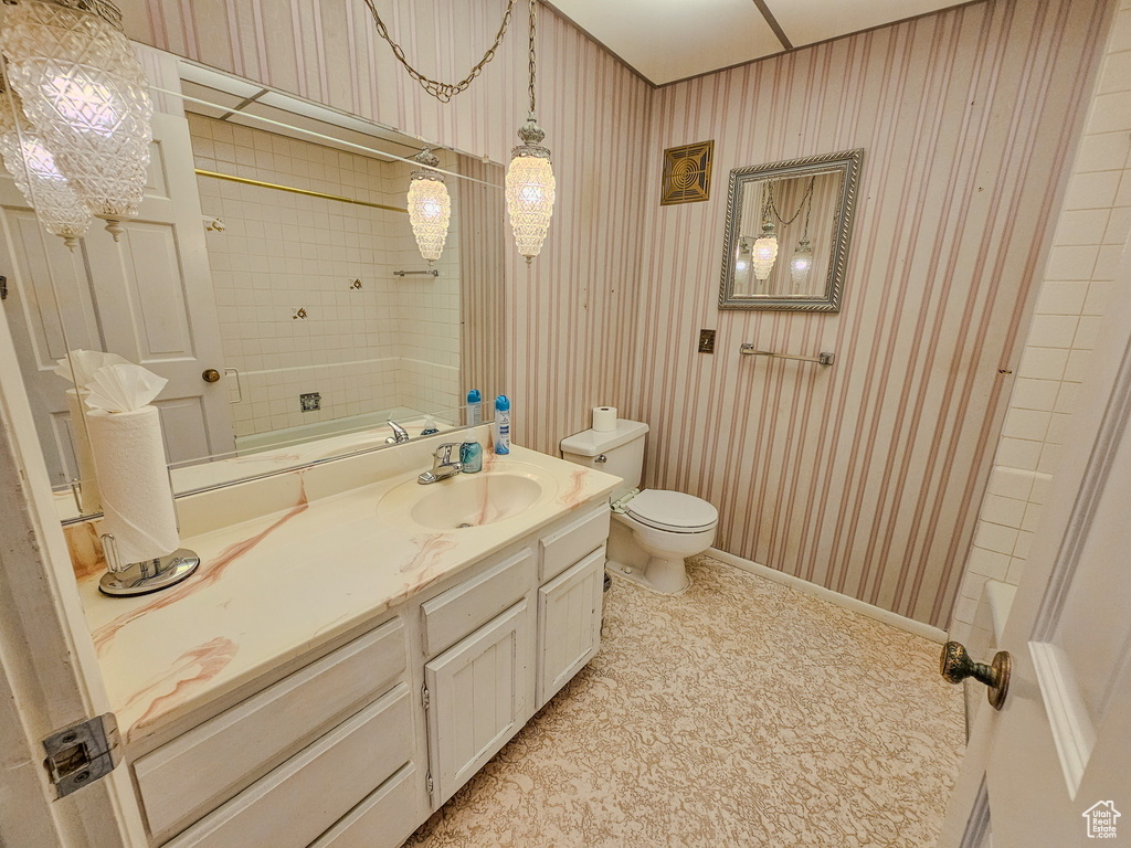 Bathroom featuring toilet, vanity, and baseboards