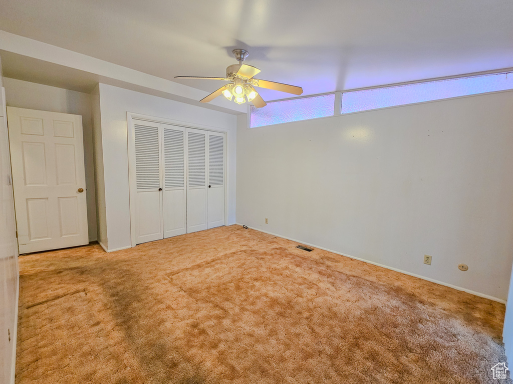 Unfurnished bedroom featuring a closet, carpet flooring, a ceiling fan, and baseboards